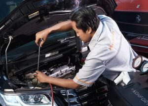 Seorang teknisi Manhattan saat servis ac mobil BMW terbaik di Malang